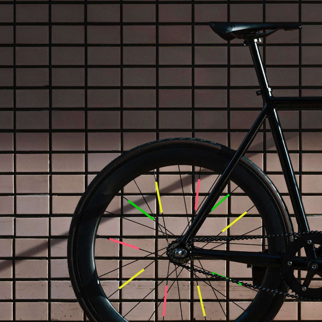 Bunte Speichenreflektoren an schwarzem Fahrrad – Seitenansicht 24 Stück im Set