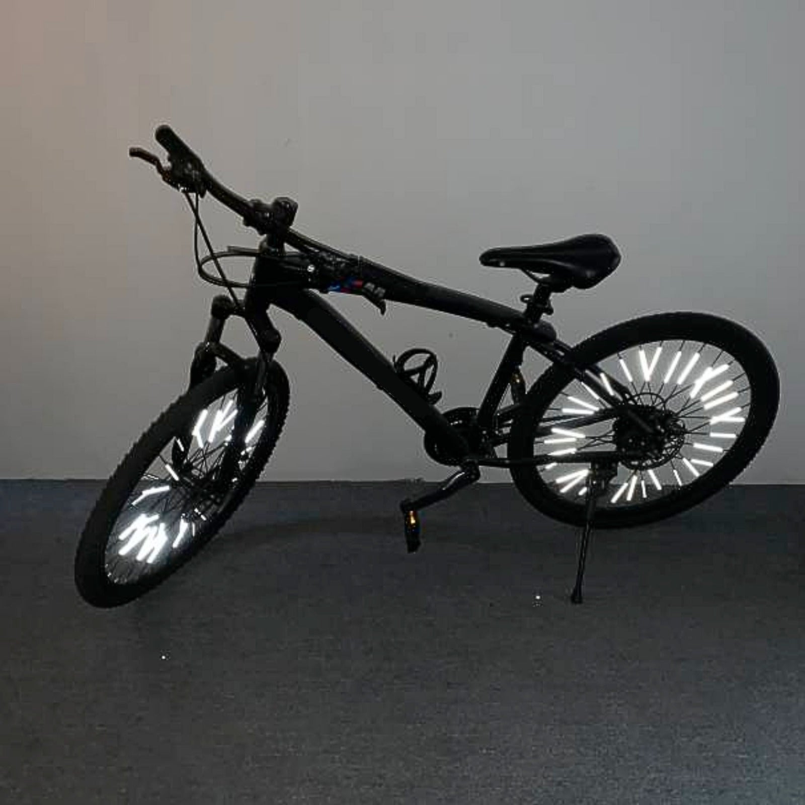 Speichenreflektoren leuchtend am schwarzen Fahrrad – Seitenansicht