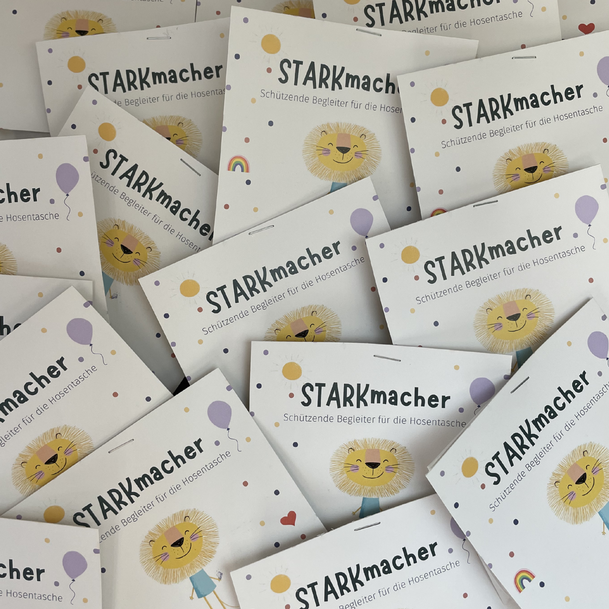 Mehrere STARKmacher-Kärtchen mit Löwen-Illustration – schützende Begleiter für die Hosentasche